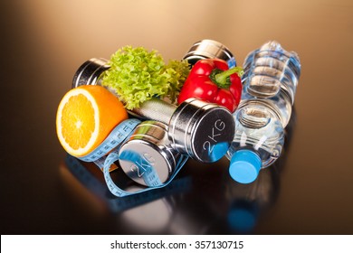 fitness equipment and healthy food on black surface