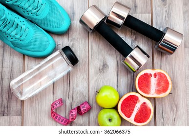Fitness equipment. Healthy food. Sneakers, water,apple  on wooden background - Shutterstock ID 362066375