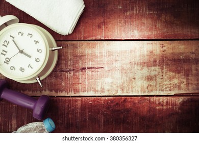 Fitness Equipment, Old Clock On Wood Background For Schedule Of The Day.