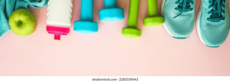 Fitness equipment on pink background. Sneakers, dumbbells, towel and bottle of water. Long banner format. - Powered by Shutterstock