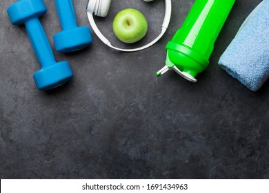 Fitness equipment on a stone background. Top view flat lay with copy space for workout plan