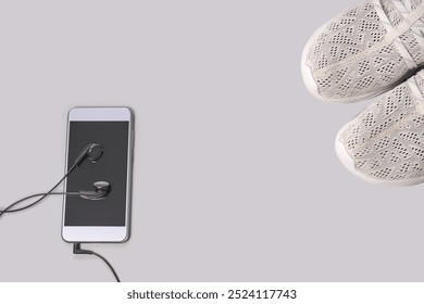 Fitness essentials: stylish sneakers and smartphone with headphones for a perfect workout. - Powered by Shutterstock