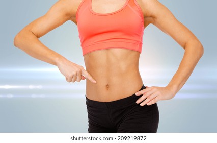 Fitness, Exercise And Diet Concept - Close Up Of Woman Pointing Finger At Her Six Pack