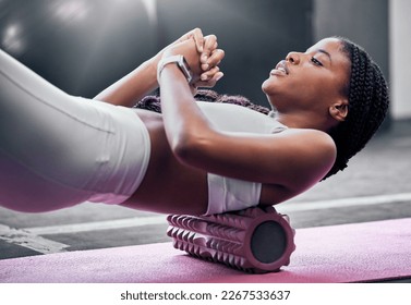 Fitness, exercise and foam roller with a black woman in gym, training during a workout for health. Yoga, wellness and pilates with a female athlete exercising in a sports club for physiotherapy