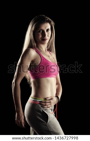 Similar – Close up front portrait of one young athletic woman in sportswear in gym over dark background, standing in boxing stance with hands and fists, looking at camera