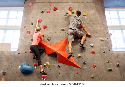 fitness, extreme sport, bouldering, people and healthy lifestyle concept - man and woman exercising at indoor climbing gym - Powered by Shutterstock