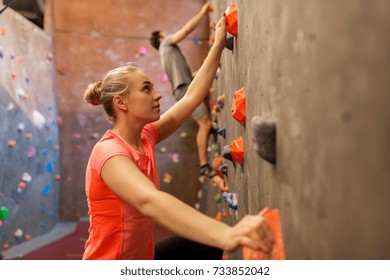 Fitness, Extreme Sport, Bouldering, People And Healthy Lifestyle Concept - Man And Woman Exercising At Indoor Climbing Gym