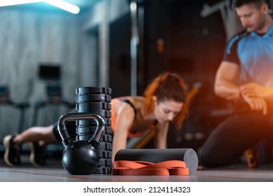 fitness female exercising plank with personal trainer with equipment in gym - Shutterstock ID 2124114323