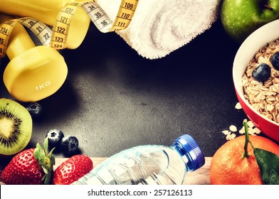 Fitness frame with dumbbells, water bottle and fresh fruits. Healthy lifestyle concept with copy space