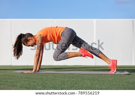 Fitness girl doing abs exercise to tone stomach muscles. Tiger curl reverse crunch planking bodyweight floor workout. Asian fit woman training outdoors on exercise mat. Gym lifestyle.