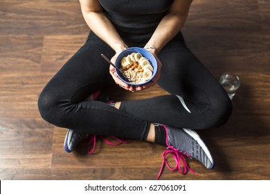 Fitness girl eating oatmeal porridge