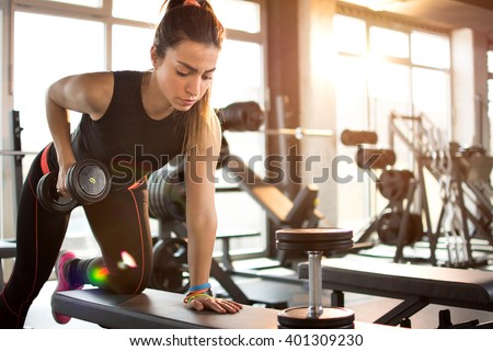  Fitness girl lifting dumbbell in the morning.