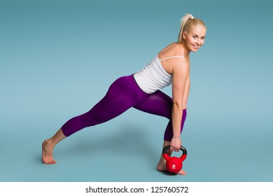 Fitness Girl In One Arm Row Position With A Kettlebell