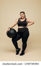 Fitness Girl. Plus Size Model With Pilates Ball Full-Length Portrait. Smiling Full-Figured Woman In Black Sportswear. Body Positive And Sport As Lifestyle.