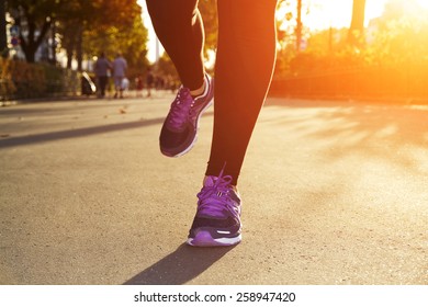 Fitness Girl running at sunset in city center
