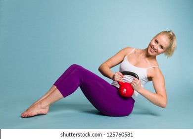 Fitness Girl In Russian Twist Position With A Kettlebell