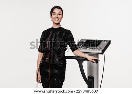 Fitness girl trainer before workout in EMS suit. Sport training in electrical muscle stimulation suit. Fit girl in EMS suit on white background