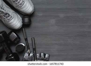 Fitness Gym Equipment On Black Wooden Background With Copy Space.