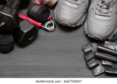 Fitness Gym Equipment On Black Wooden Background With Copy Space.