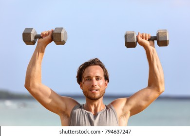 Fitness Gym Man Lifting Dumbbell Weights. Male Athlete With Muscular Arms With Dumbbells Overhead Doing Shoulder Press Training Biceps. Athlete Holding Two Free Heavy Weights.