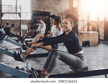 Fitness, gym and woman on rowing machine for health, wellness and body workout with class. Endurance, exercise and female athlete on ergometer equipment for cardio training in sports center. - Powered by Shutterstock