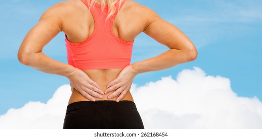 Fitness-, Gesundheits- und Medizingkonzept - Nahaufnahme sportlicher Frauen, die sich den Rücken berührt