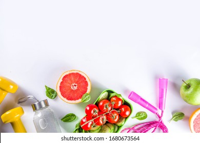 Fitness And Healthy Food Lifestyle Concept. Dumbbells, Diet Fruit And Vegetable Lunch Box, Water And Jump Rope On White Background. Flatlay Image, Top View Copy Space