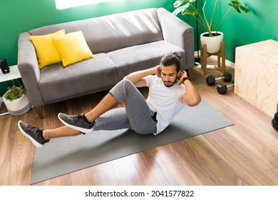 Fitness Hispanic Man Doing Bicycle Crunches On An Exercise Mat During A HIIT Cardio Training 