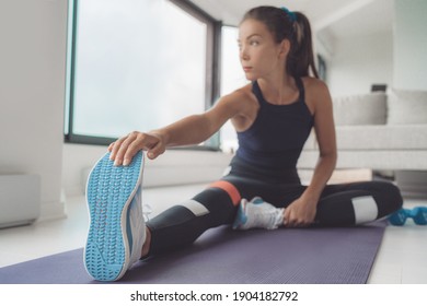 Fitness At Home Asian Woman Stretching Leg Muscles On Exercise Mat For Training Pilates Or Hiit Workout. Closeup Of Running Shoes.