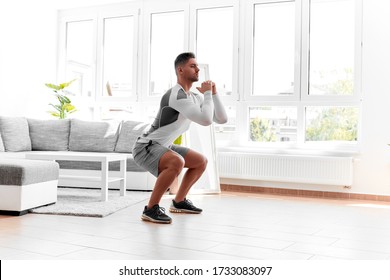 Fitness At Home, Man Doing Squats In A Bright Room