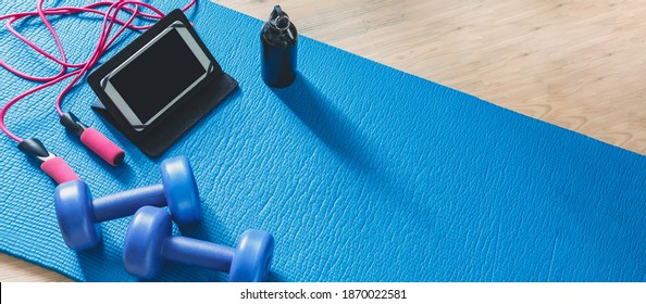 Fitness At Home, Remote Training With Virtual Instructor. Woman In Sportswear Sitting On The Floor With Dumbbells Laptop At Home. Sports And Recreation Concept In Lockdown With Fitness Apps Online