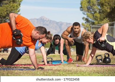 Fitness instructor with people exercising in outdoor bootcamp - Powered by Shutterstock