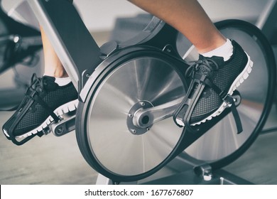 Fitness machine at home woman biking on indoor cycling stationary bike exercise indoors for cardio workout. Closeup of shoes on bicycle. - Shutterstock ID 1677676807
