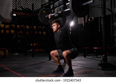 Fitness man doing aweight training by lifting barbell. Young athlete training alone. Bodybuilder lifting weight doing squats. Cross instructor fit at gym. Sport concept - Powered by Shutterstock