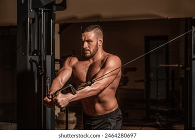 Fitness man execute exercise with exercise-machine Cable Crossover in gym. Handsome man with big muscles in gym. Machine in the gym. - Powered by Shutterstock