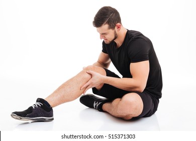 Fitness Man Injured. In Studio. Knee Injury. Isolated White Background