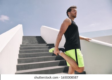 Fitness Man Runner Getting Ready To Run Stretching Legs Warm Up Quad Stretch Exercise On Outdoor Staircase Cardio HIIT Workout.