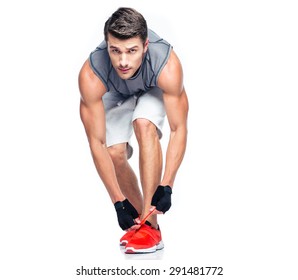 Fitness Man Tie Shoelaces Isolated On A White Background. Looking At Camera