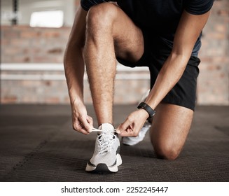 Fitness, man and tying shoe lace getting ready for running exercise, workout or training at gym. Sporty male, person or guy shoes in preparation for sport run, cardio or warm up on floor at gymnasium - Powered by Shutterstock