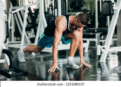 Fitness man warming up in gym. Female doing warmup stretching workout on Gym background.