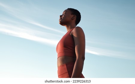 Fitness, meditation and woman on blue sky to breathe fresh air, freedom and energy to exercise, workout and do yoga or cardio training outdoor in nature. Black female take breath for mental health - Powered by Shutterstock