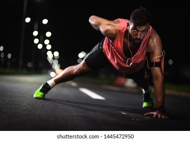 Fitness men doing push ups on the road at night. - Powered by Shutterstock