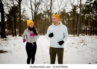 Fitness Mixed Race Couple Winter Morning Exercises On A Snowy Forest.