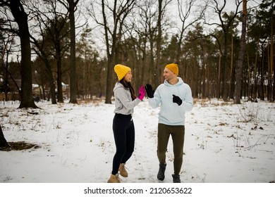 Fitness Mixed Race Couple Winter Morning Exercises On A Snowy Forest.