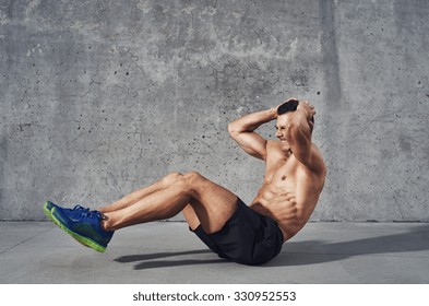 Fitness model exercising sit ups and crunches. Muscular well build, toned body with six pack sweating. Copy space - Powered by Shutterstock