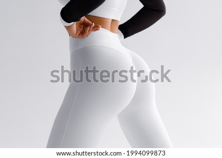 Fitness model in leggings with beautiful buttocks. 