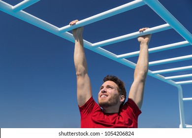 Fitness monkey bars man training arms muscles on jungle gym outdoors in summer. Athlete working out gripping climbing on ladder equipment at sport athletics centre. - Powered by Shutterstock