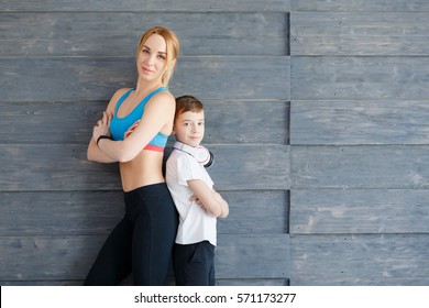 Fitness mother with her 9 years old son. Sports mom with kid relaxing after morning work-out at home. Mum and child do the exercises together, healthy family lifestyle concept