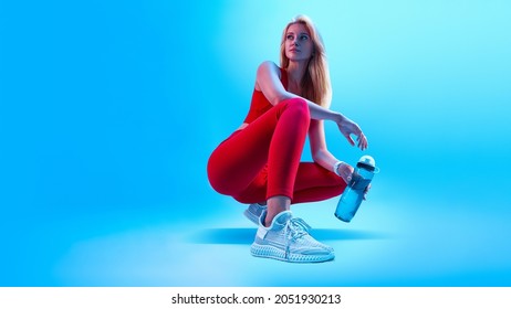 Fitness neon light sporty concept portrait of fitness female model in abstract style background. Health care concept. Healthy lifestyle. Fitness woman taking break after at gym - Powered by Shutterstock
