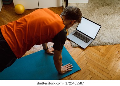 Fitness Online Exercise. Man Training From Internet At Home. A Sporty Man In Sportswear Working Out Doing Arm Plank. Mockup Blank Modern Laptop Screen. Video Live Streaming Stay Home Workout